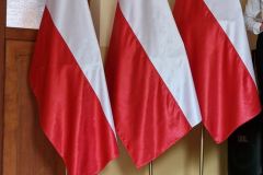 Trzy biało-czerwone flagi stoją w stojakach