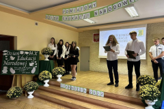 Uczniowie stoją na scenie, w tle napis Dzień Edukacji Narodowej, Powiatowy Dzień Edukacji Narodowej Czarnocin 2023