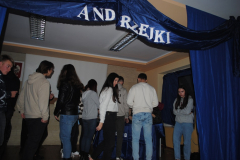 Młodzież stoi, nad nimi wisi napis andrzejki