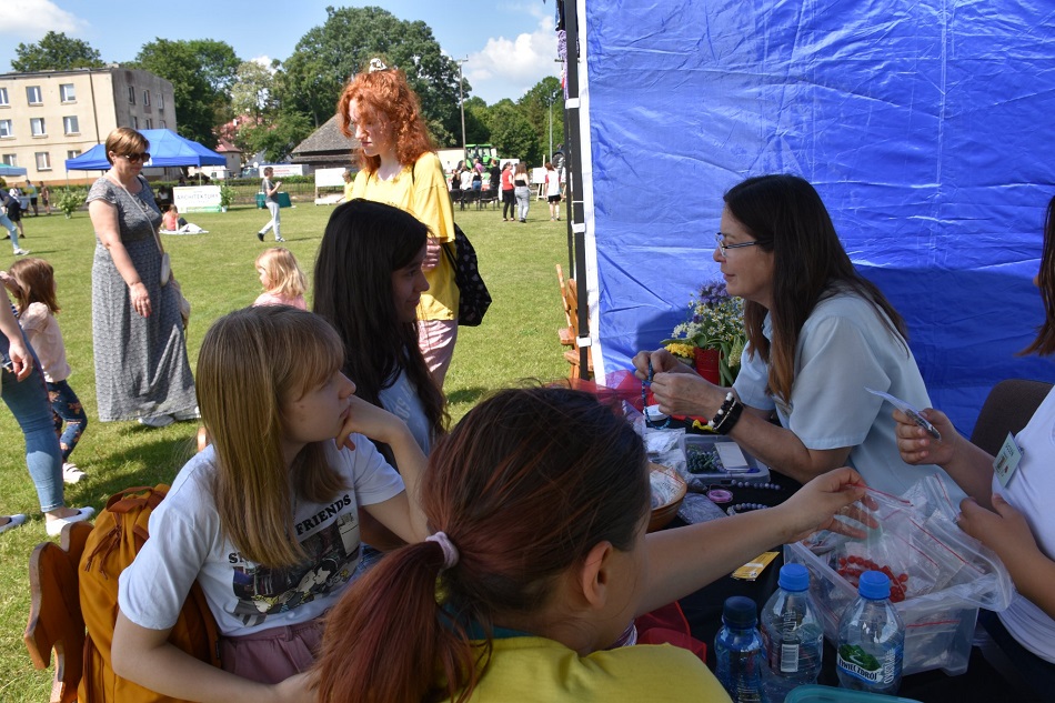 Uczennice siedzą i robią biżuterię z koralików