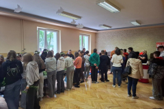 Młodzież stoi, w tle okna