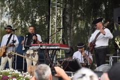 Zdjecie przestawia osoby z instrumentami muzycznymi na scenie