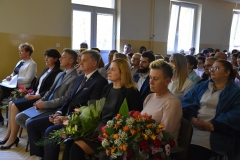 Nauczyciele i uczniowie siedzą w tle okna