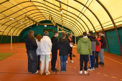 Grupa osób stoi w hali sportowej