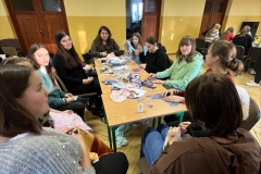 Uczniowie siedzą przy stole na którym leżą materiały