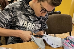 Uczeń wycina z materiału formę maskotki