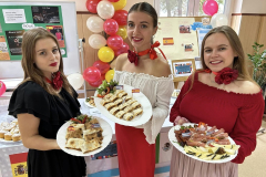 Uczenncice stoją i trzymają w rękach talerze z potrawami