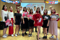 Młodzież z wachlarzami w ręku stojąc pozuje do zdjęcia