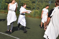 Uczniowie biegną z wazonem na boisku