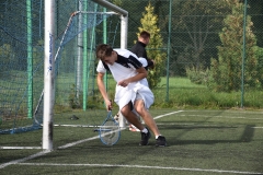 Uczeń kreci się wokół rakiety od tenisa, w tle bramka