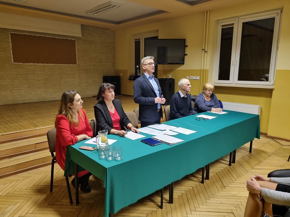 Kobiety i mężczyzna siedzą przy stole, dyrektor stoi