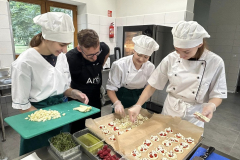 Uczennice układają na brytfannach ciastka