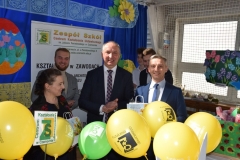 Wójt Gminy Czarnocin, dyrektor szkoły i uczniowie stoją, przed nimi balony żółte i zielone