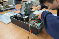 Uczeń wyjmuje część z jednostki komputerowej