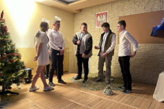 Pastuszkowie i aniołowie stoją obok choinki