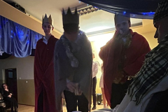 Trzej Królowie stoją przy żłobie w którym leży Jezus