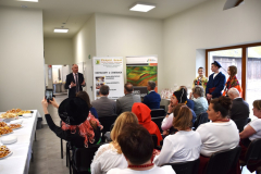 Wójt Gminy Czarnocin stoi, pozostałe osoby siedzą, w tle banery reklamowe