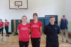 Trzy dziewczyny stoją, w tle inne osoby