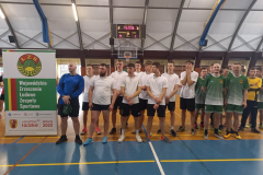 Młodzież stoi obok banera z napisem Wojewódzkie Zrzeszenie Ludowe Kluby Sportowe