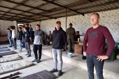 Uczniowie stoją pod zadaszeniem, w tle ściana