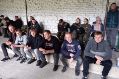 Uczniowie siedzą na schodku, w tle ściana