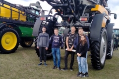 Uczniowie stoją, w tle maszyny rolnicze