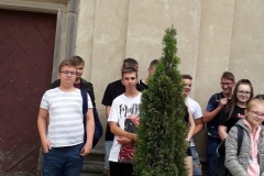 Uczniowie stoją przed wejściem do świątyni, w tle ściana