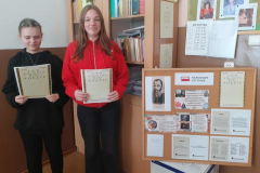 Kobiety stoją z książkami w rękach, w tle szafa