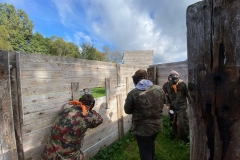 Trzech uczniów stoi w tle drzewa