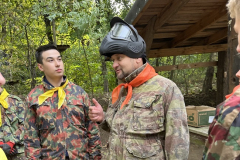 Nauczyciel i uczeń stoją, w tle drzewa, wiata