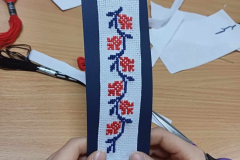 Wyhaftowany kawałek materiału na granatowym kartoniku