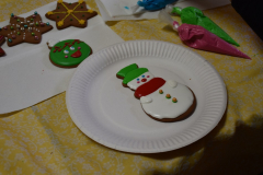 Ulukrowany bałwanek piernikowy leży na talerzu papierowym