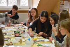 Młodzież lukruje pierniki, w tle okno