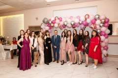 UcZennice i nauczyciel stojąc pozyją do zdjęcia, w tle balony