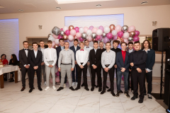 Uczniowie stojąc pozują do zdjęcia