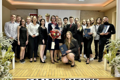 Absolwenci wraz z wychowawczynią stojąc pozują do zdjęcia