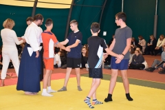 Uczniowie i instruktor aikido stoją na macie