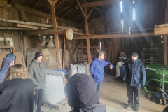 Mężczyźni stoją w tle worki, słupy drewniane