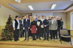 Uczniowie i nauczyciele pozują na stojąco do zdjęcia