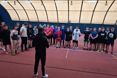 grupa osób stoi w hali sportowej