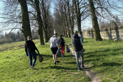 Grupa osób idzie ścieżką w tle drzewa