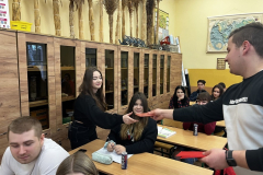 Uczeń podaje uczennicy kopertę, pozostali uczniowie siedzą