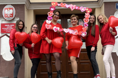 Uczennice i nauczycielki pozują z ramką w serca oraz z czerwonymi balonami do zdjęcia