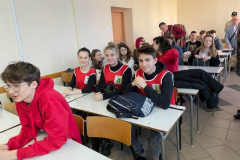 Młodzież siedzi w ławkach