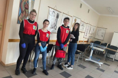 Młodzież stoi, w tle plakaty informacyjne