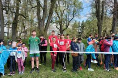 Uczestnicy biegów stoją, w tle drzewa