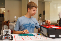 Mężczyzna siedzi przy stole na którym stoi plastikowy pojemnik