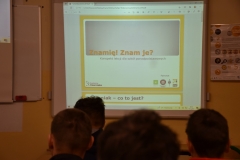 Młodzież siedzi, w tle napis znamię znam je