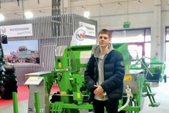 Uczeń stoi przy maszynie rolniczej