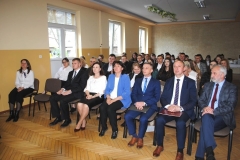 Społeczność szkolna siedzi słuchając przemówienia